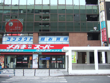 【JR新宿駅西口より】東口前のロータリーに出ると、目の前に1Fメガネスーパーのビルがあります。